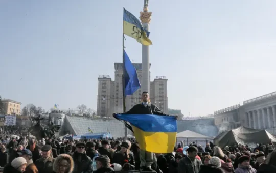 An anti-Yanukovych protester holds a Ukrainian flag in Kyiv's Independence Square